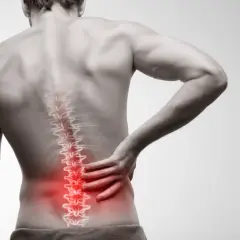 Mężczyzna odczuwa ostry ból kręgosłupa lędźwiowego promieniujący do biodra. Czerwony obszar podkreśla źródło bólu.
