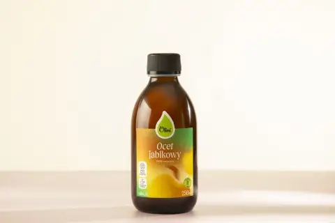Butelka naturalnego octu jabłkowego Olini, który może być pomocny jako mikstura na zapalenie stawów.