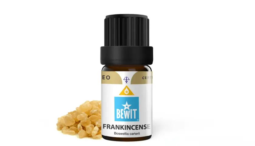 Butelka olejku eterycznego z kadzidłowcem (frankincense) obok żywicy. Elemi, czyli kadzidłowiec, to cenny składnik.
